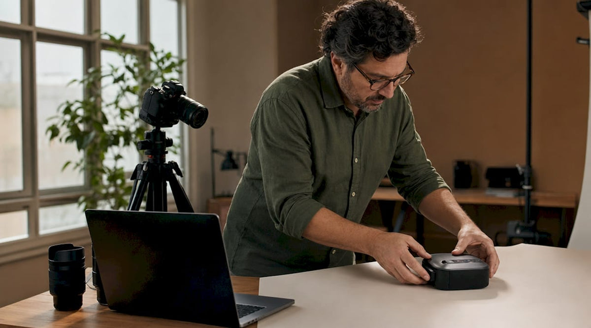 Ein Fotograf bereitet ein Produktshooting für Amazon vor und richtet dazu alles vor einem weißen Hintergrund aus.